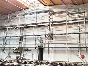 Malerarbeiten an der Innenwand einer Halle